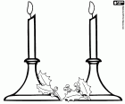 Duas velas acesas em candelabros adornados com folhas de azevinho