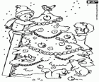 The children decorate the Christmas tree in the garden while snows